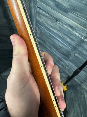 Hand holding a wooden object with a blurred background