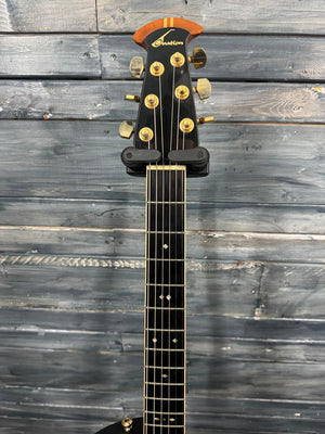 Guitar headstock with brand logo against a wooden background