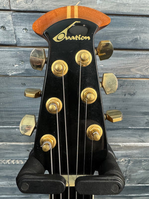 Guitar headstock with tuning pegs against a wooden background