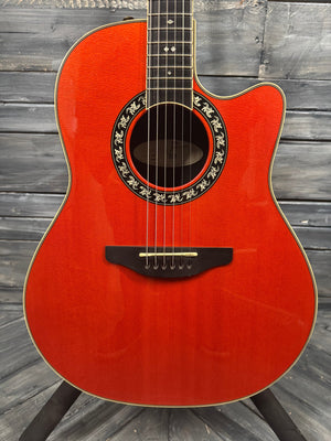 Red acoustic guitar on a wooden background