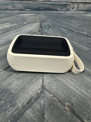 Beige portable speaker on a textured stone surface