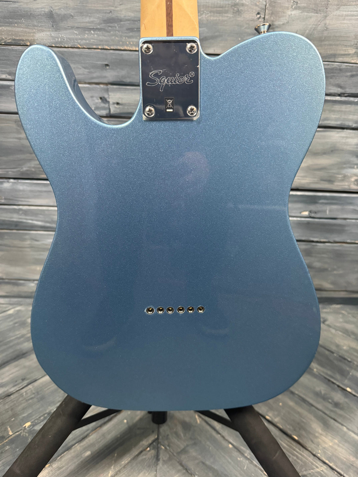 Blue electric guitar body on a wooden surface