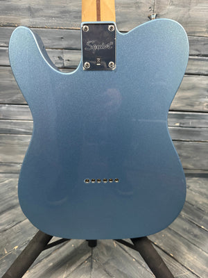 Blue electric guitar body on a wooden surface