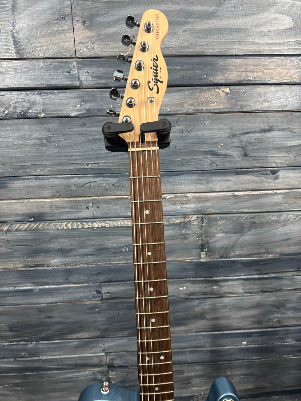 Guitar neck with headstock on a wooden surface