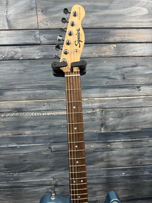 Guitar neck with headstock on a wooden surface