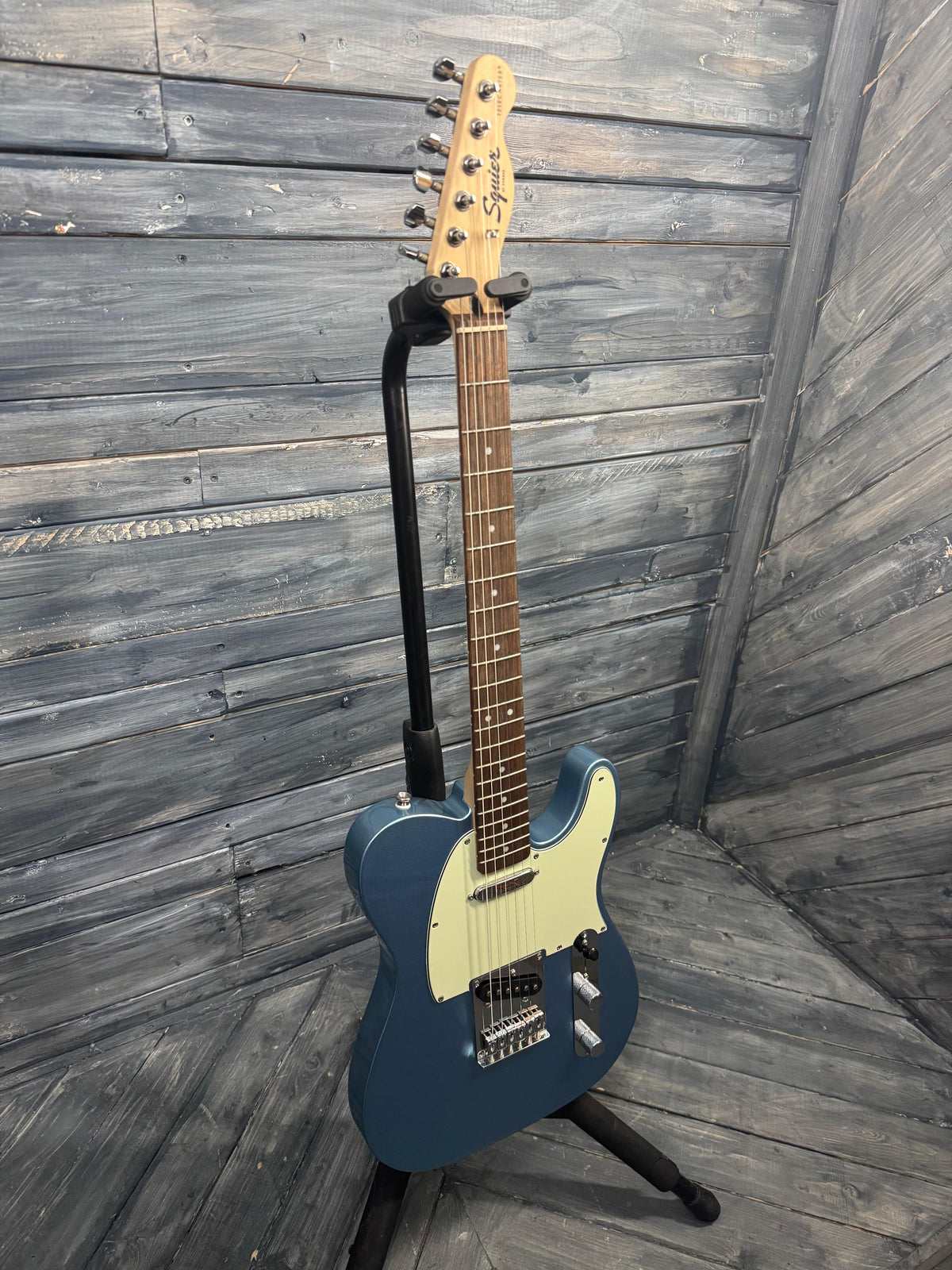 Blue electric guitar on a wooden floor