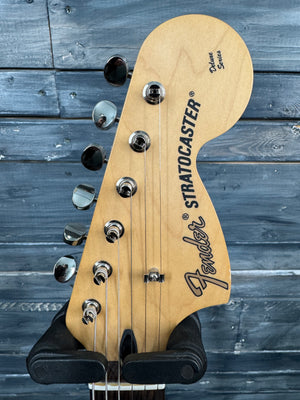 Fender Stratocaster guitar headstock on a wooden background