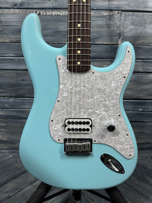 Turquoise electric guitar with a wooden fretboard on a wooden background