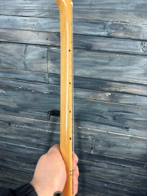 Hand holding a wooden object against a wooden background