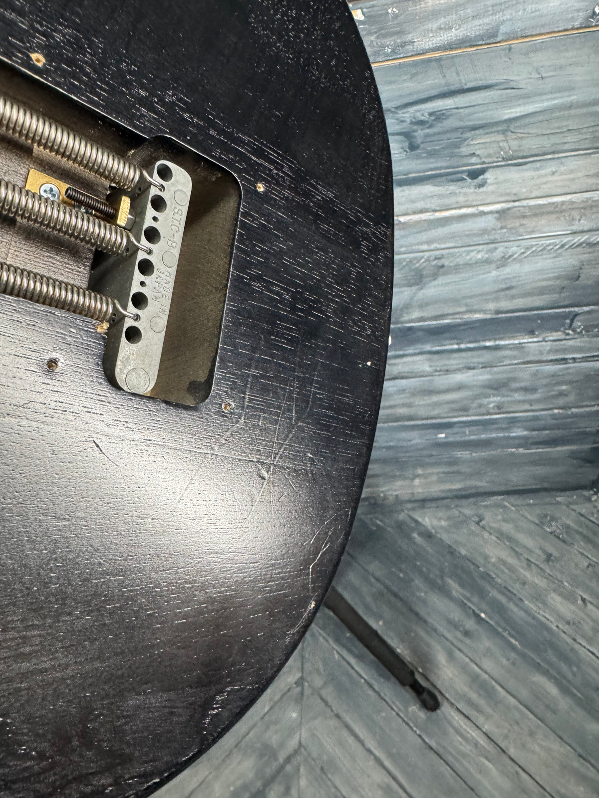 Metal bracket on a wooden surface with a wooden floor background