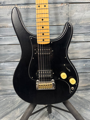 Black electric guitar with a wooden fretboard on a wooden stand