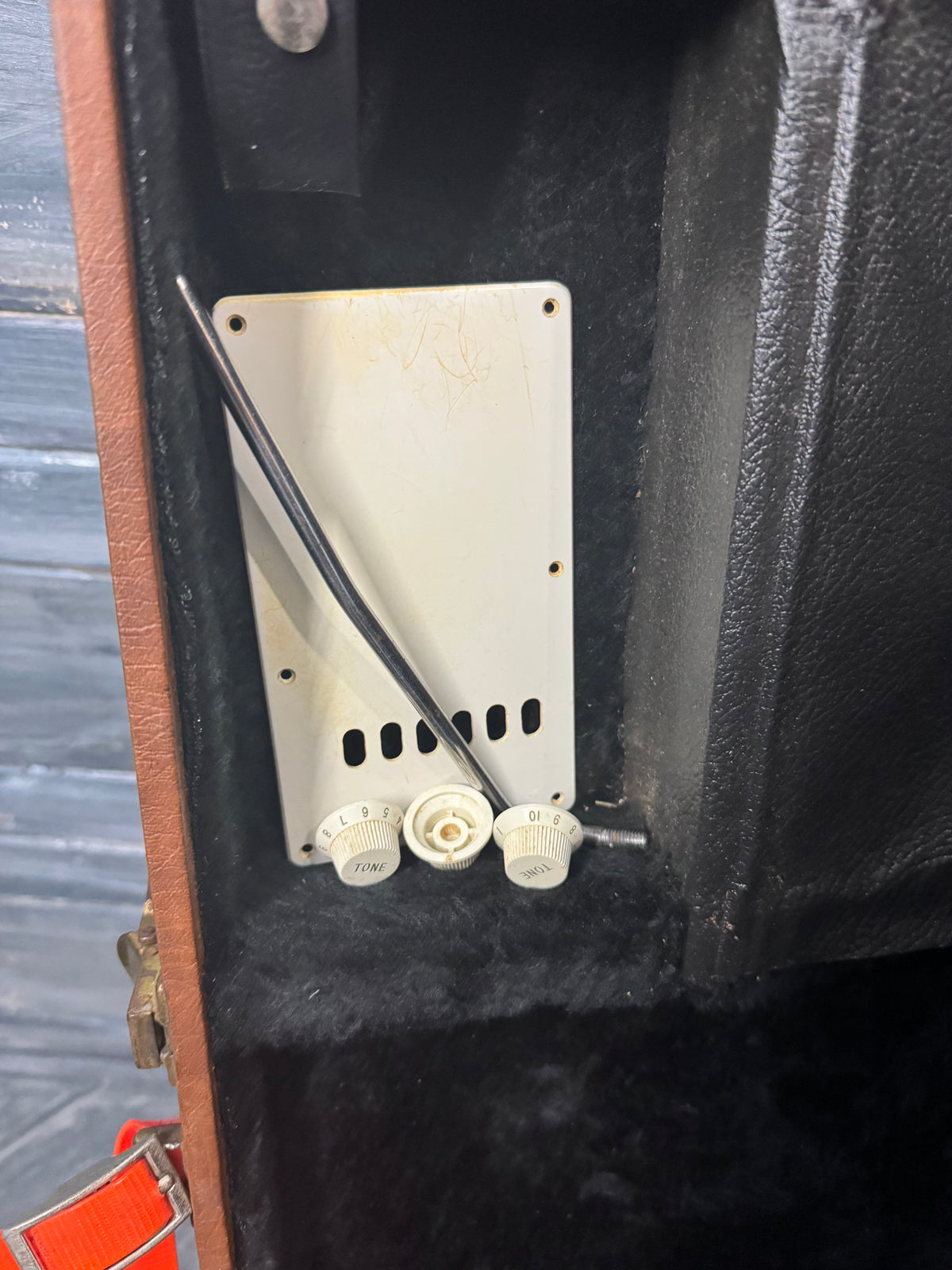 Close-up of a guitar amplifier with a control panel and cables.