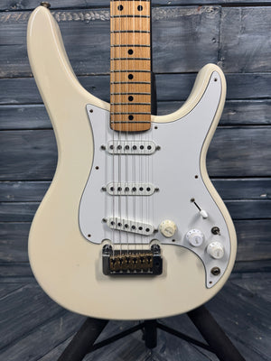 Beige electric guitar on a stand against a wooden background