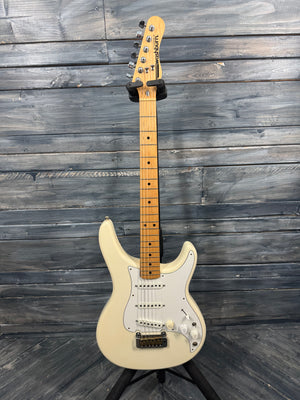 Beige electric guitar on a stand against a wooden background