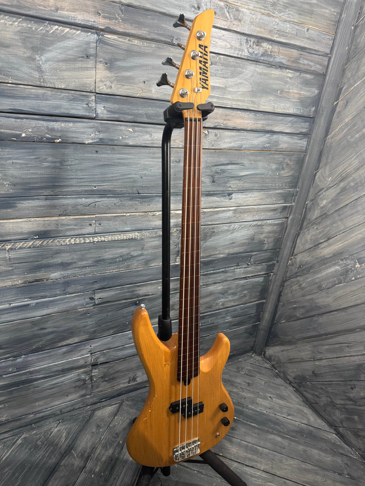 Yellow bass guitar on a wooden floor