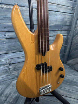Bass guitar with a wooden body on a wooden floor