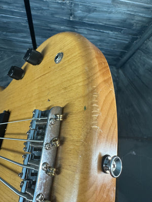 Close-up of a guitar's bridge and tuning pegs with a blurred background