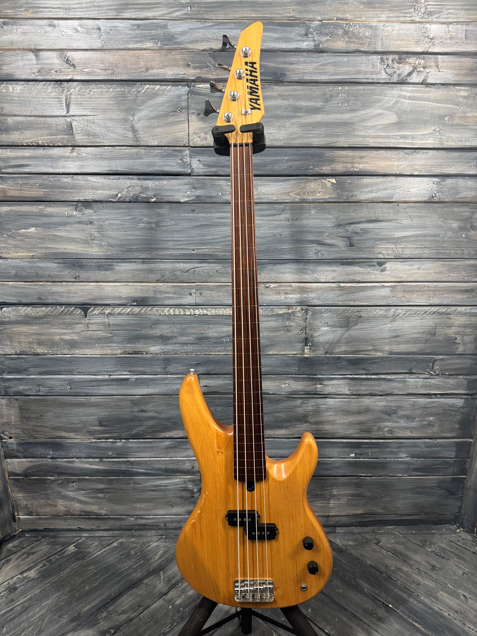 Bass guitar with a visible brand logo against a wooden background
