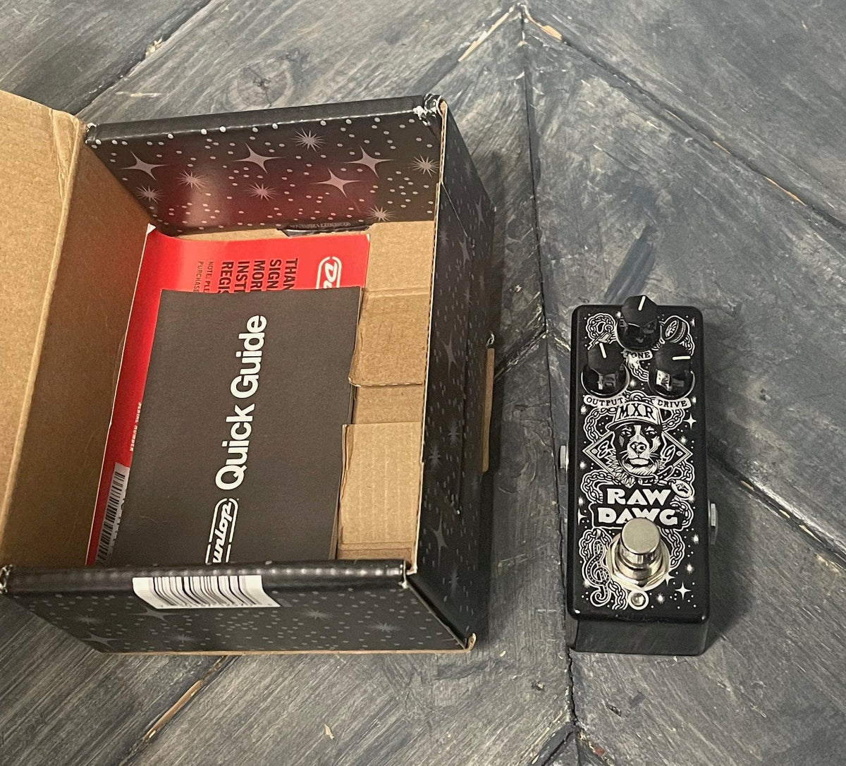MXR Raw Dawg EG74 Eric Gales Overdrive Pedal next to box with paperwork inside